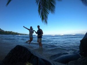 Nari mit ihrem Ehemann in Costa Rica mit dem Meer und Palmen im Hintergrund